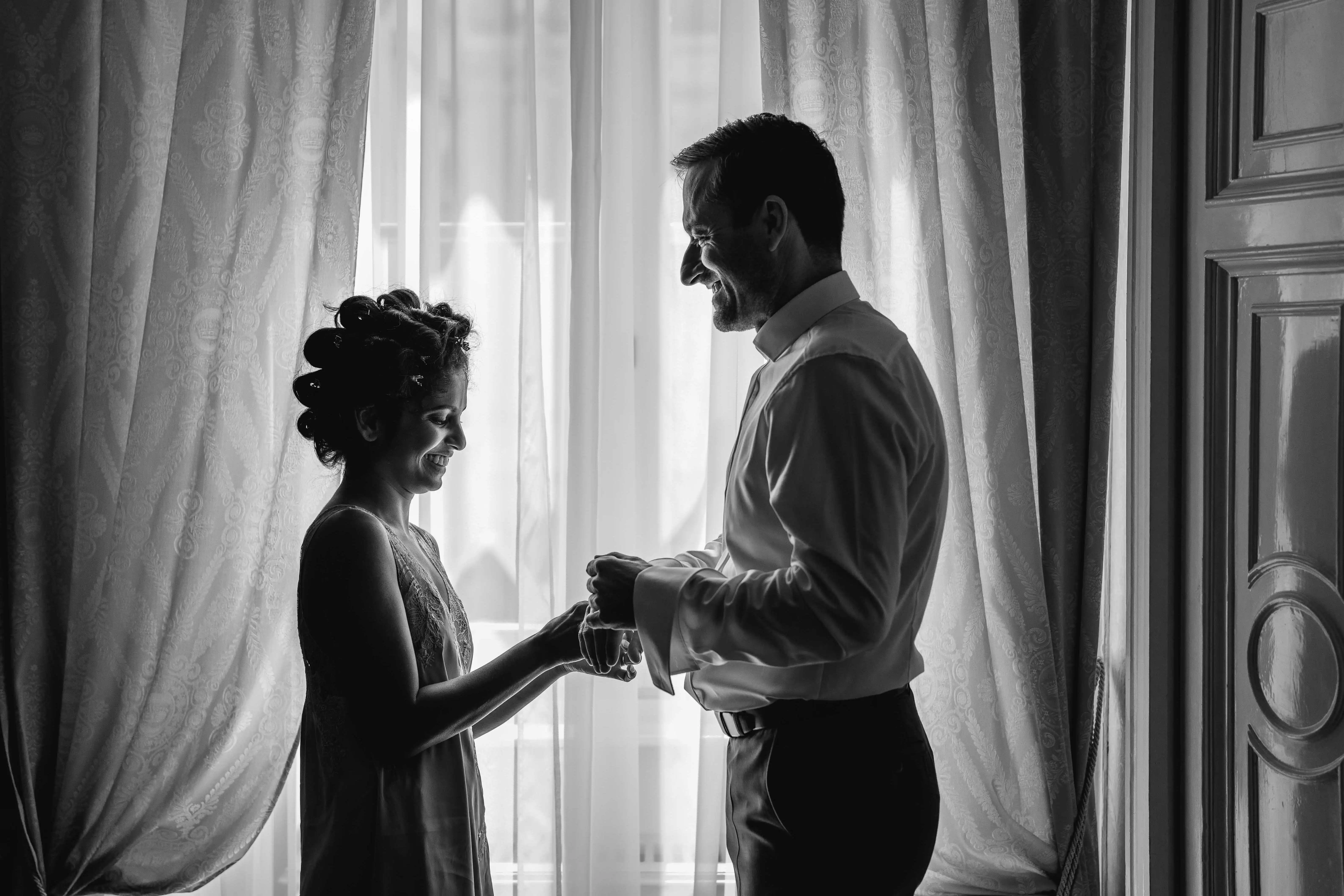 bride and groom together by window emotional moment black and white