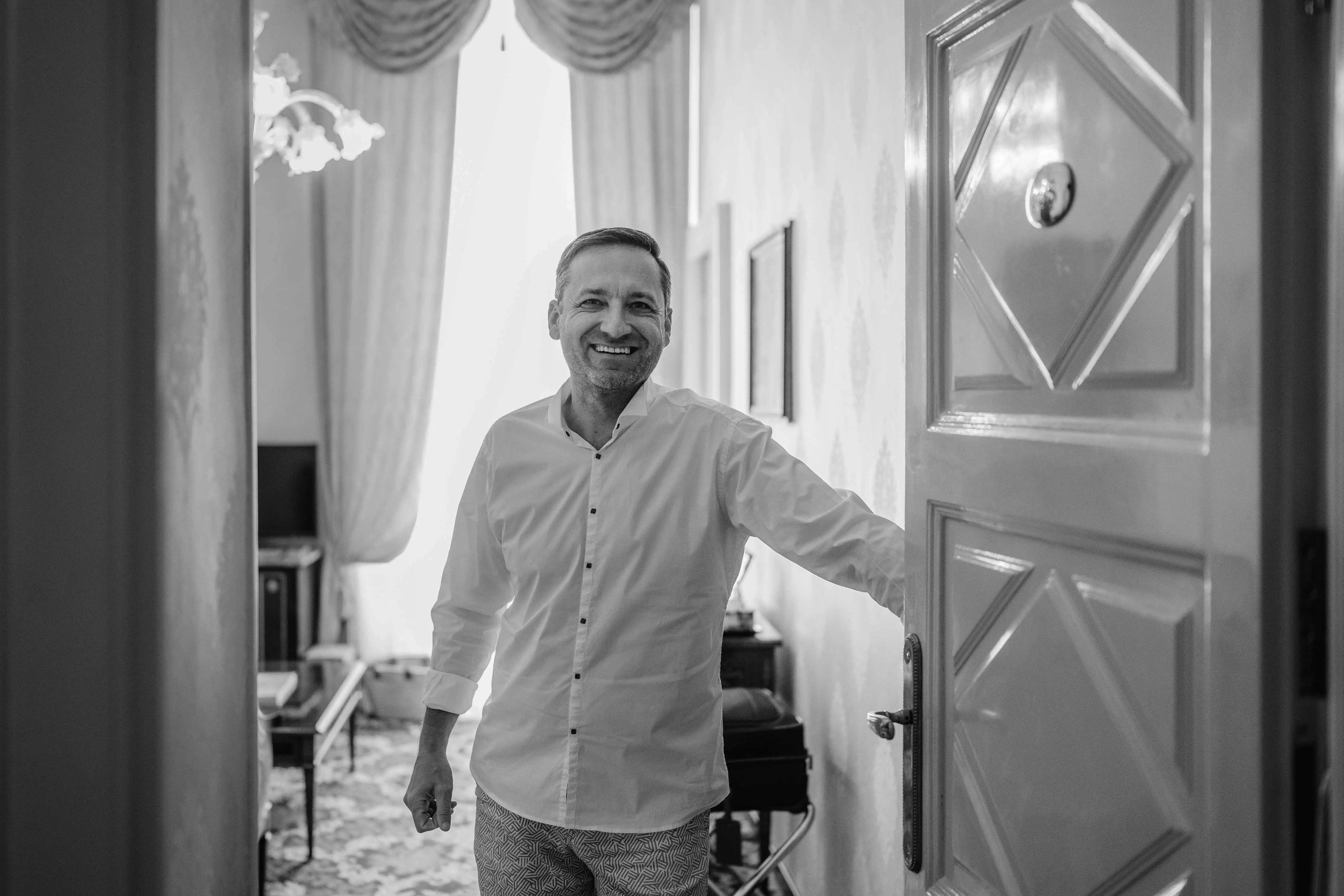 Groom getting ready in elegant Italian villa room before destination wedding in Italy