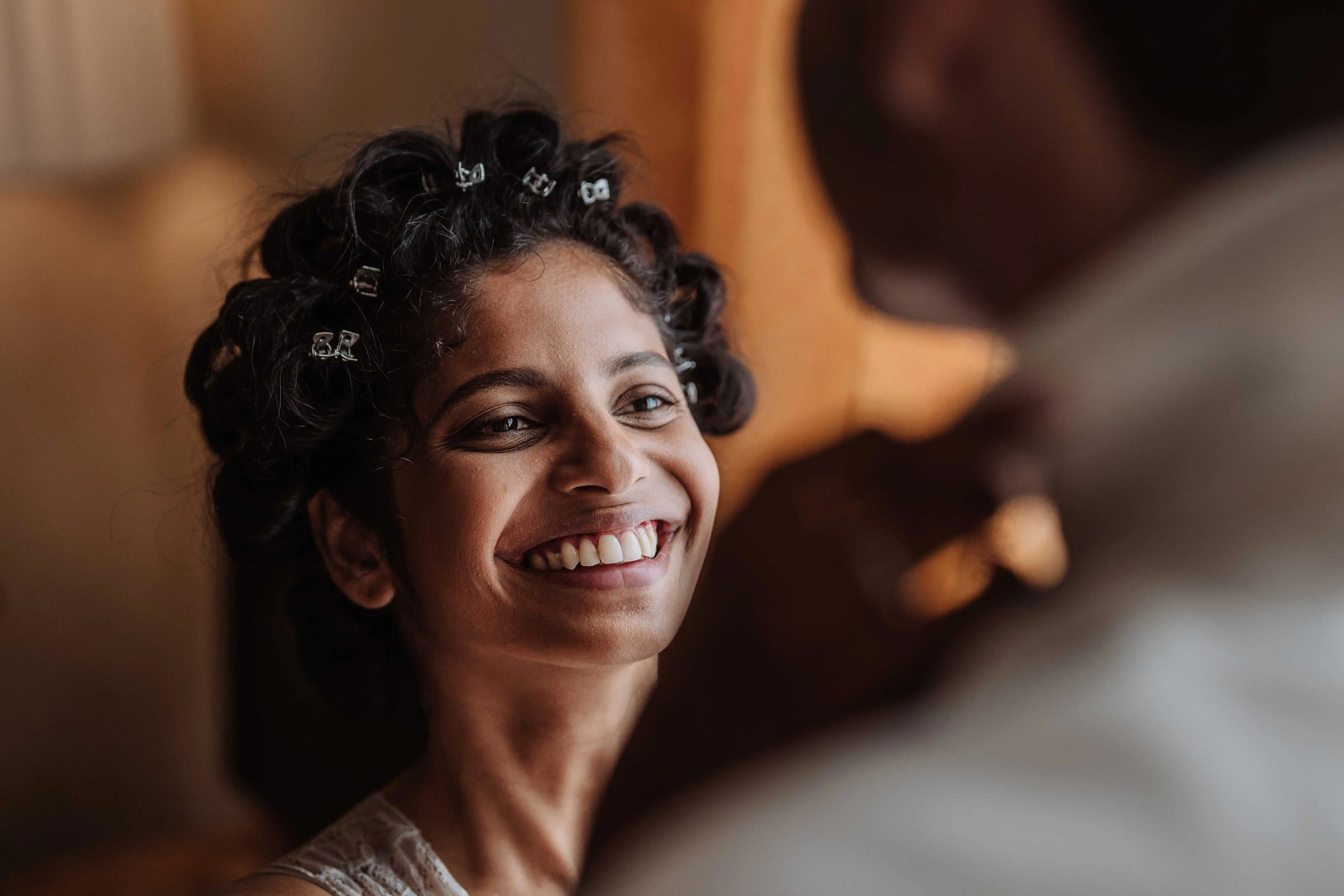 Portrait of smiling bride during wedding preparations in warm natural light