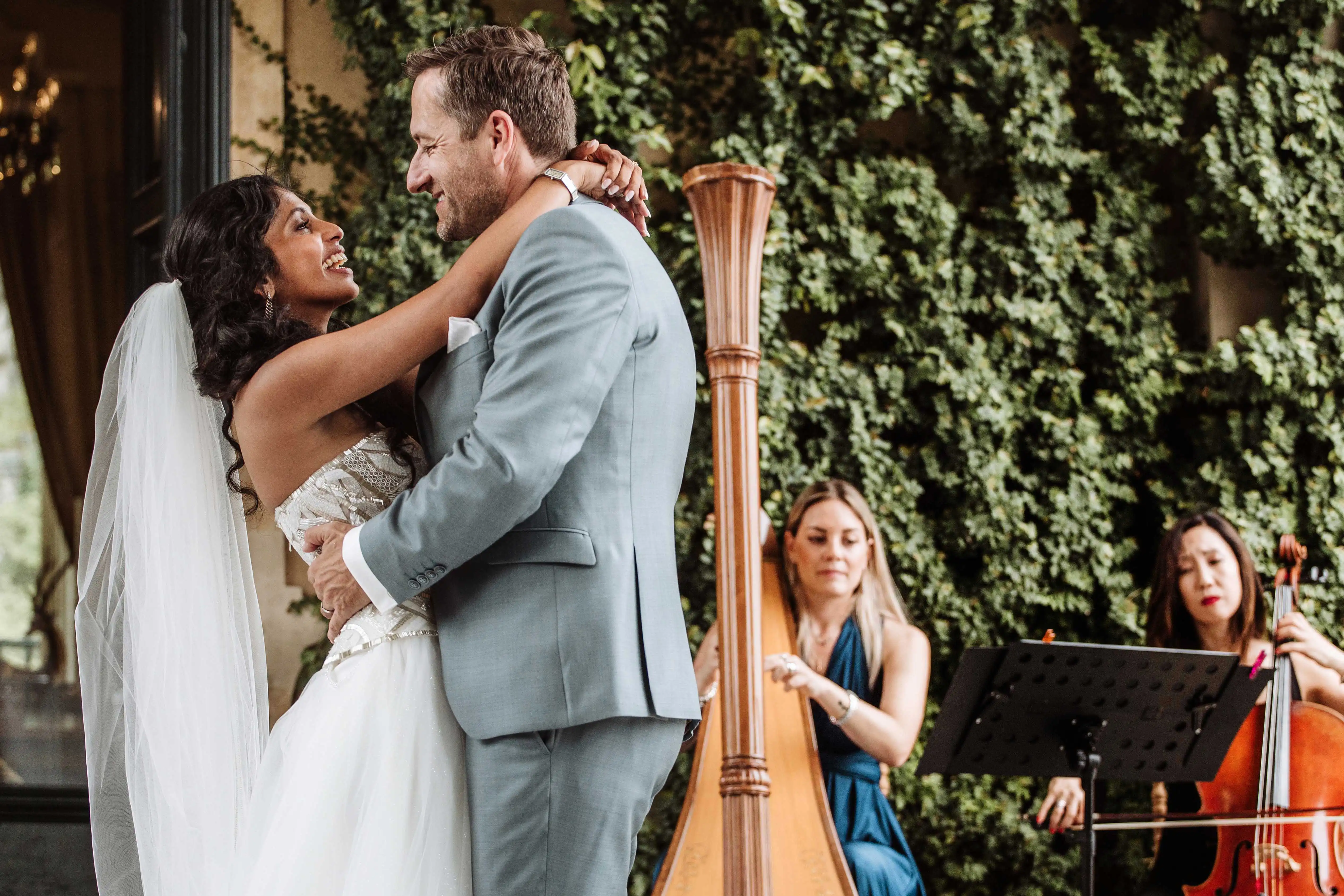 Couple smiling at each other during an outdoor wedding ceremony with live musicians and harp at Lake Como