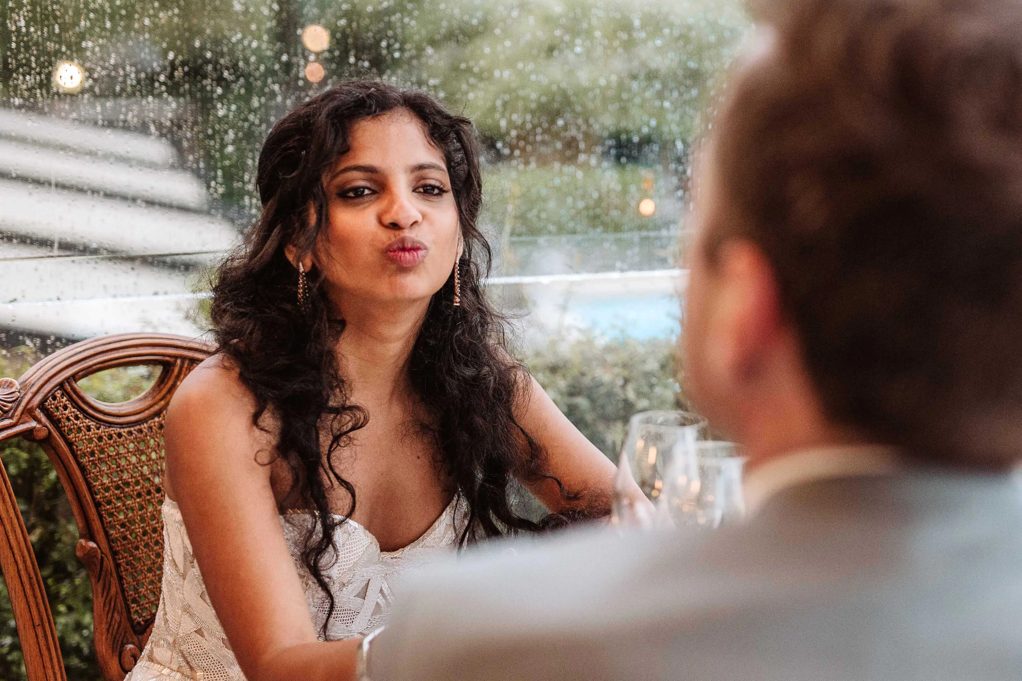Bride blowing a kiss across the table during an intimate wedding moment