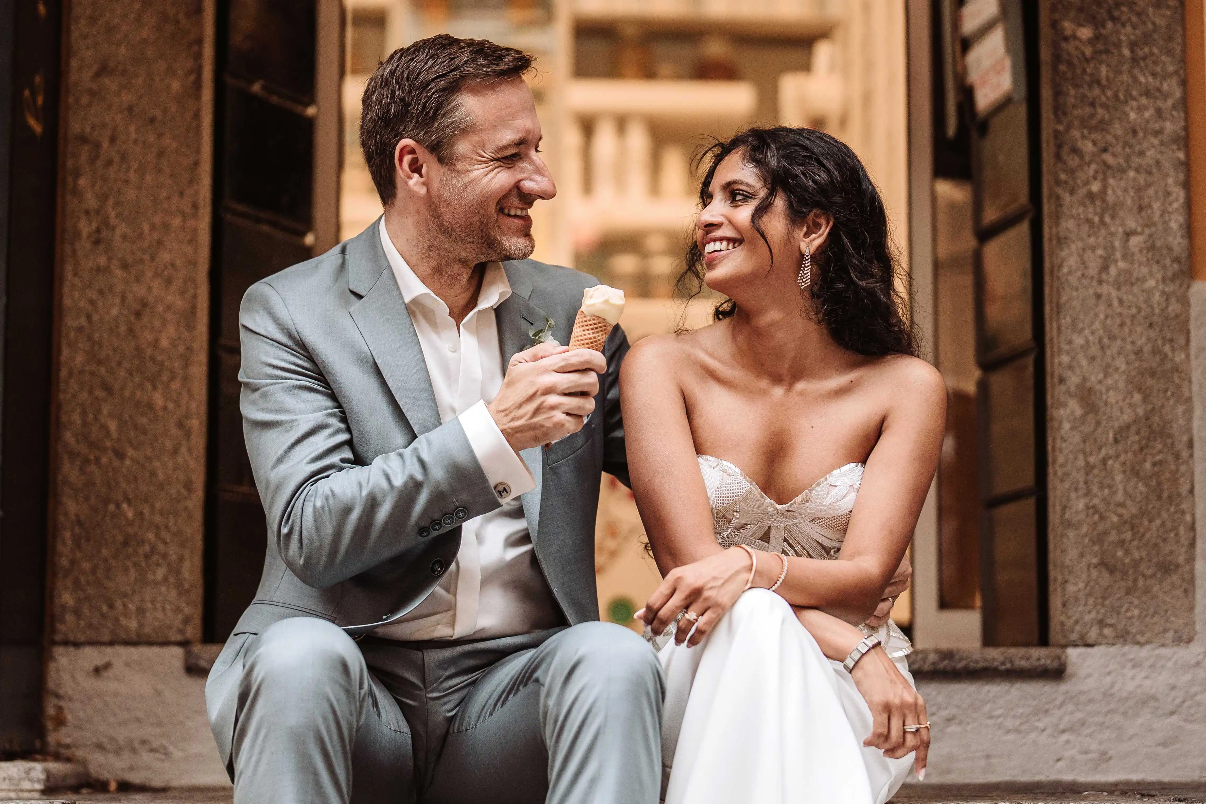 Romantic couple sharing gelato outside a traditional Italian gelateria during a Lake Como wedding day