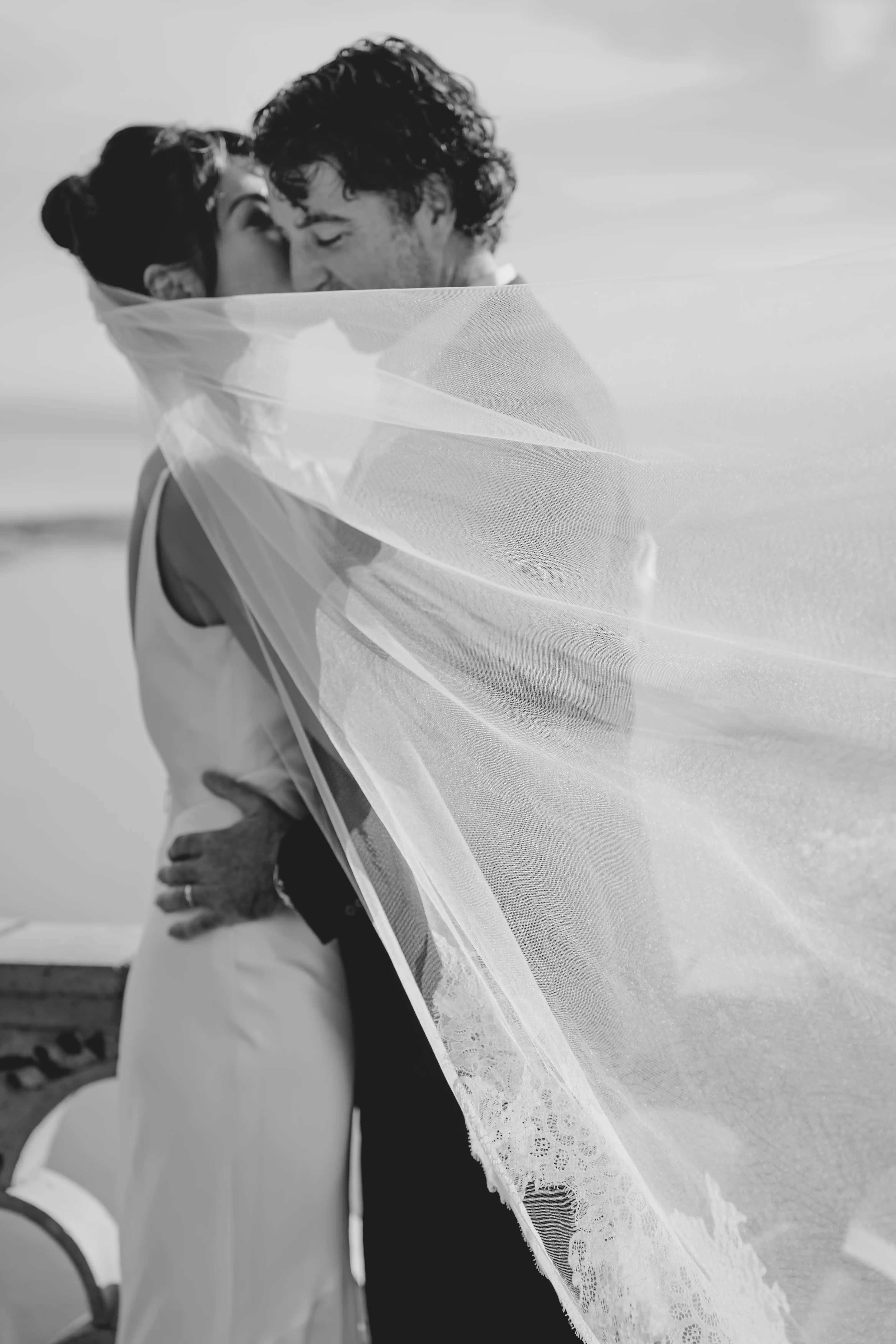 Black and white romantic kiss with veil in Sicily destination wedding