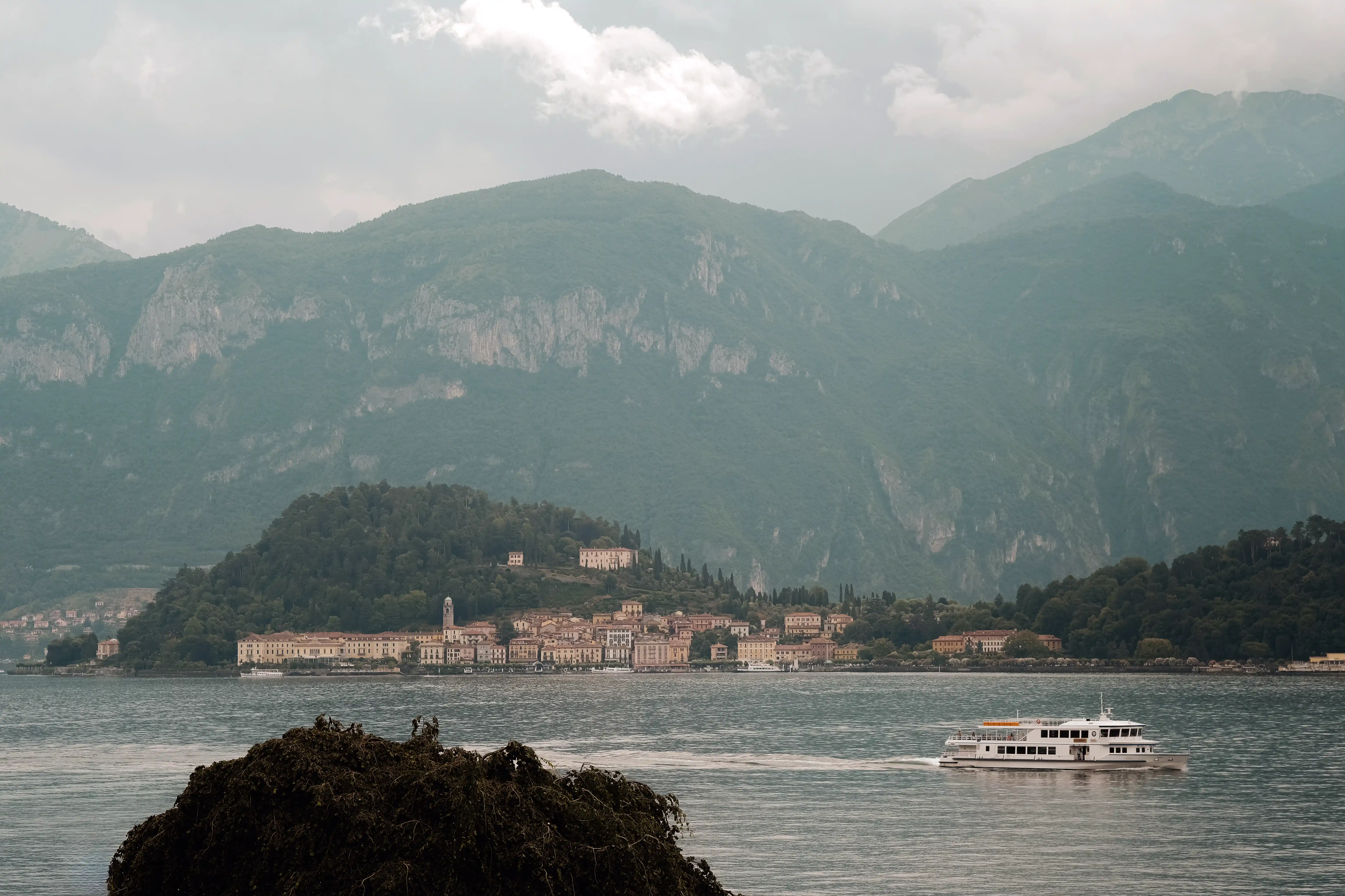 Panoramic view of Lake Como with a lakeside village and misty mountains, romantic elopement atmosphere