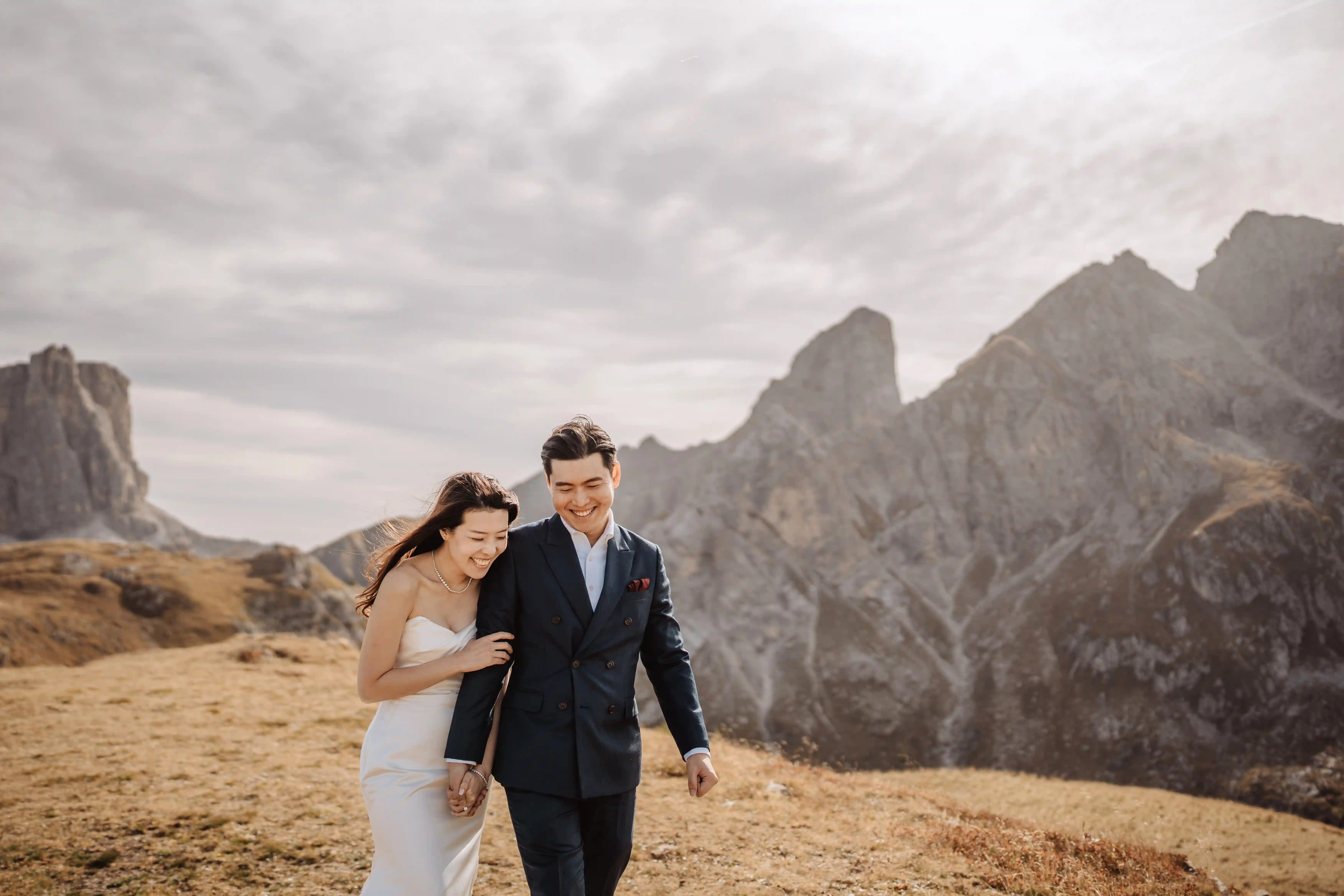 Romantic couple walking together in the Dolomites mountains during a sunset elopement session