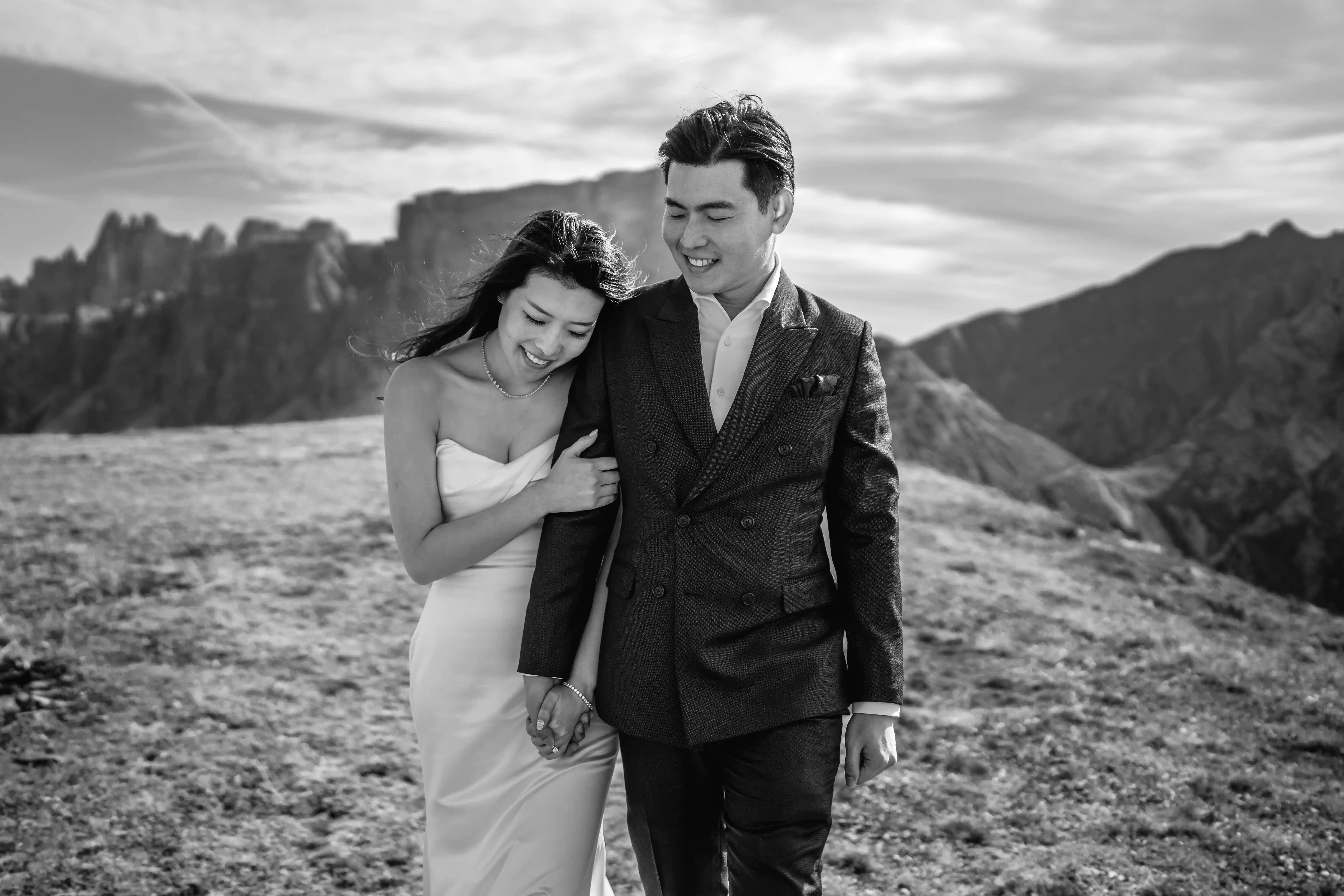 Intimate black and white portrait of bride and groom walking together in the Dolomites