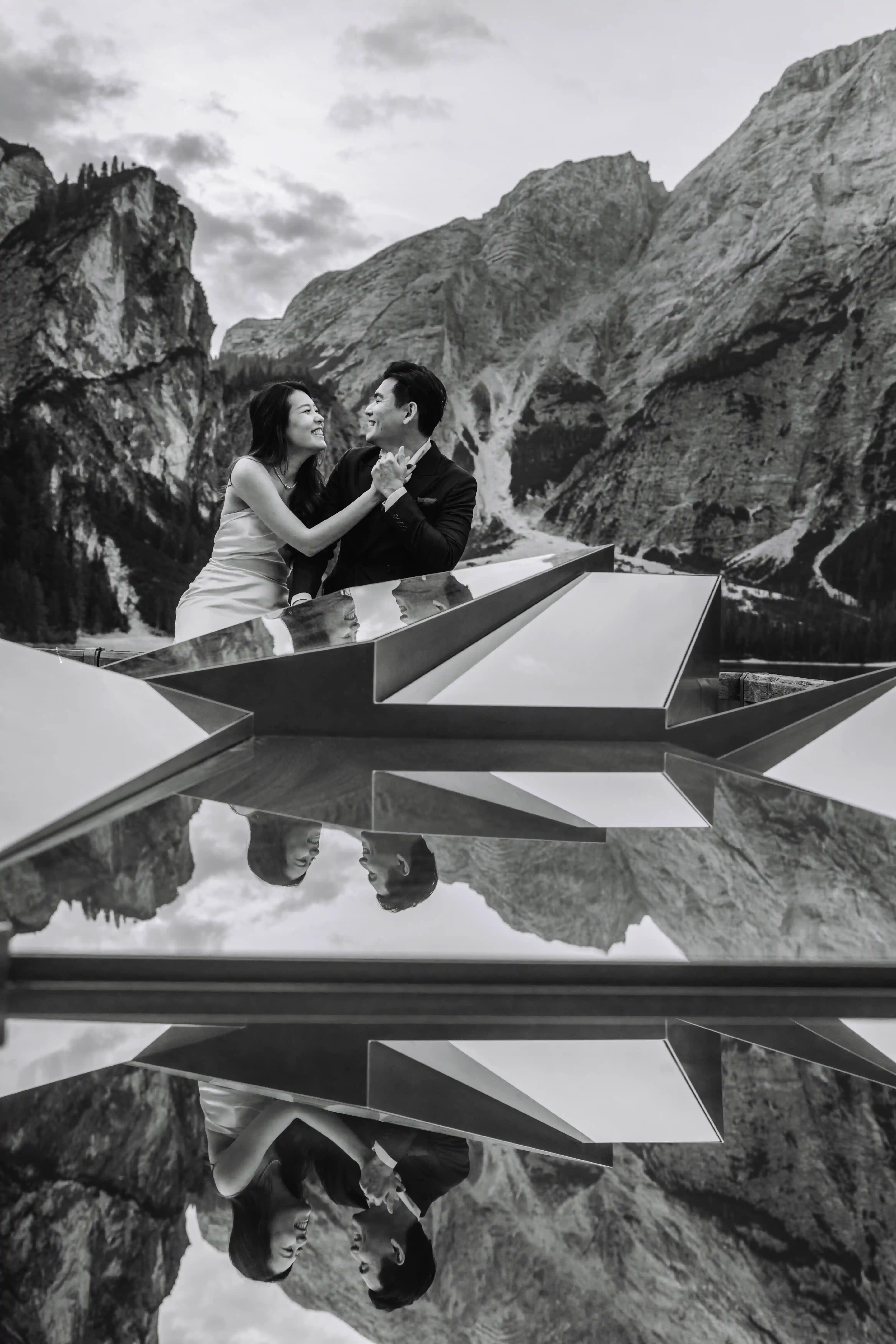 Black and white portrait of couple reflected on water at Lake Braies in the Dolomites