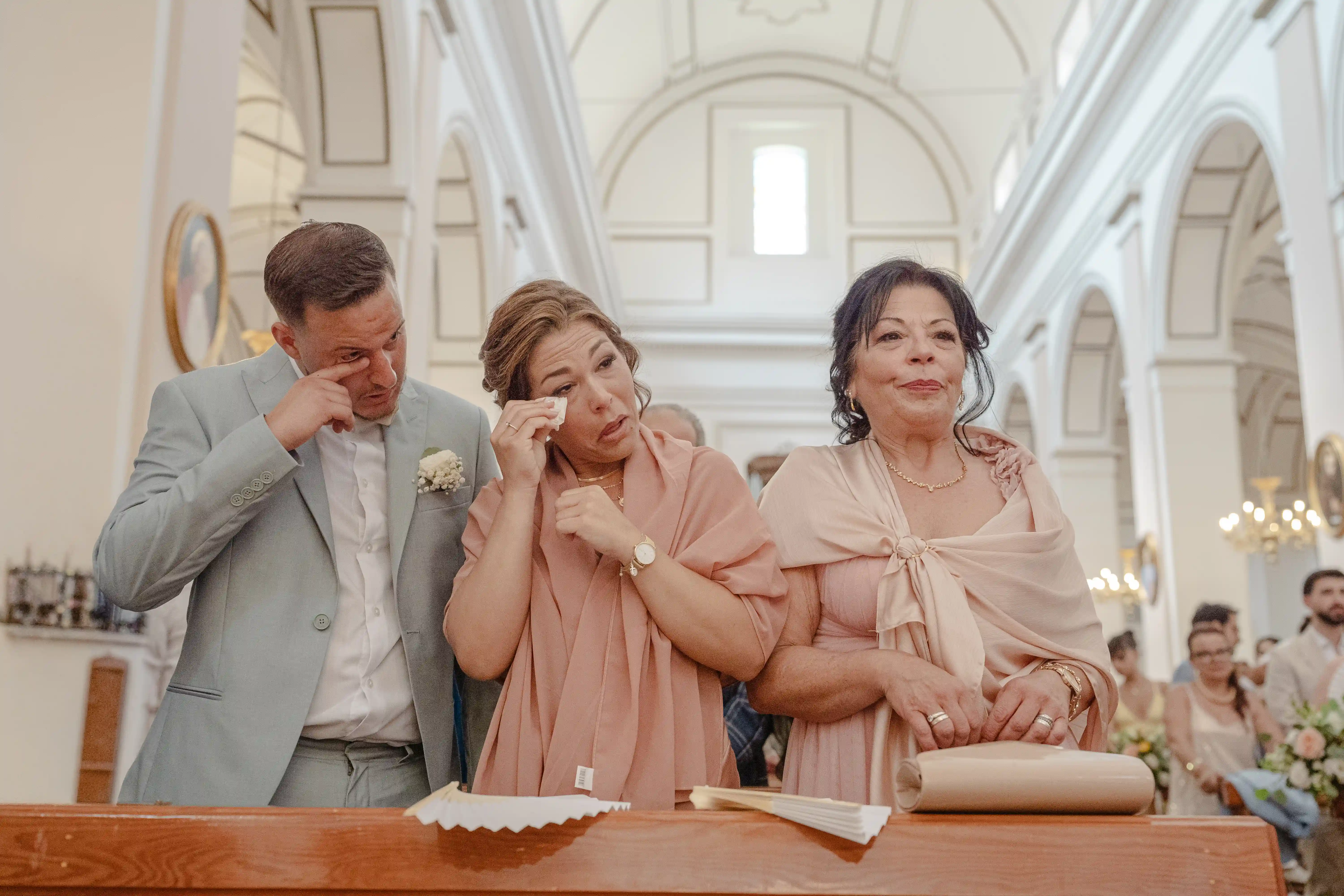 Guests emotional during wedding ceremony in church Emotional wedding guests wiping tears during a church ceremony in Sicily