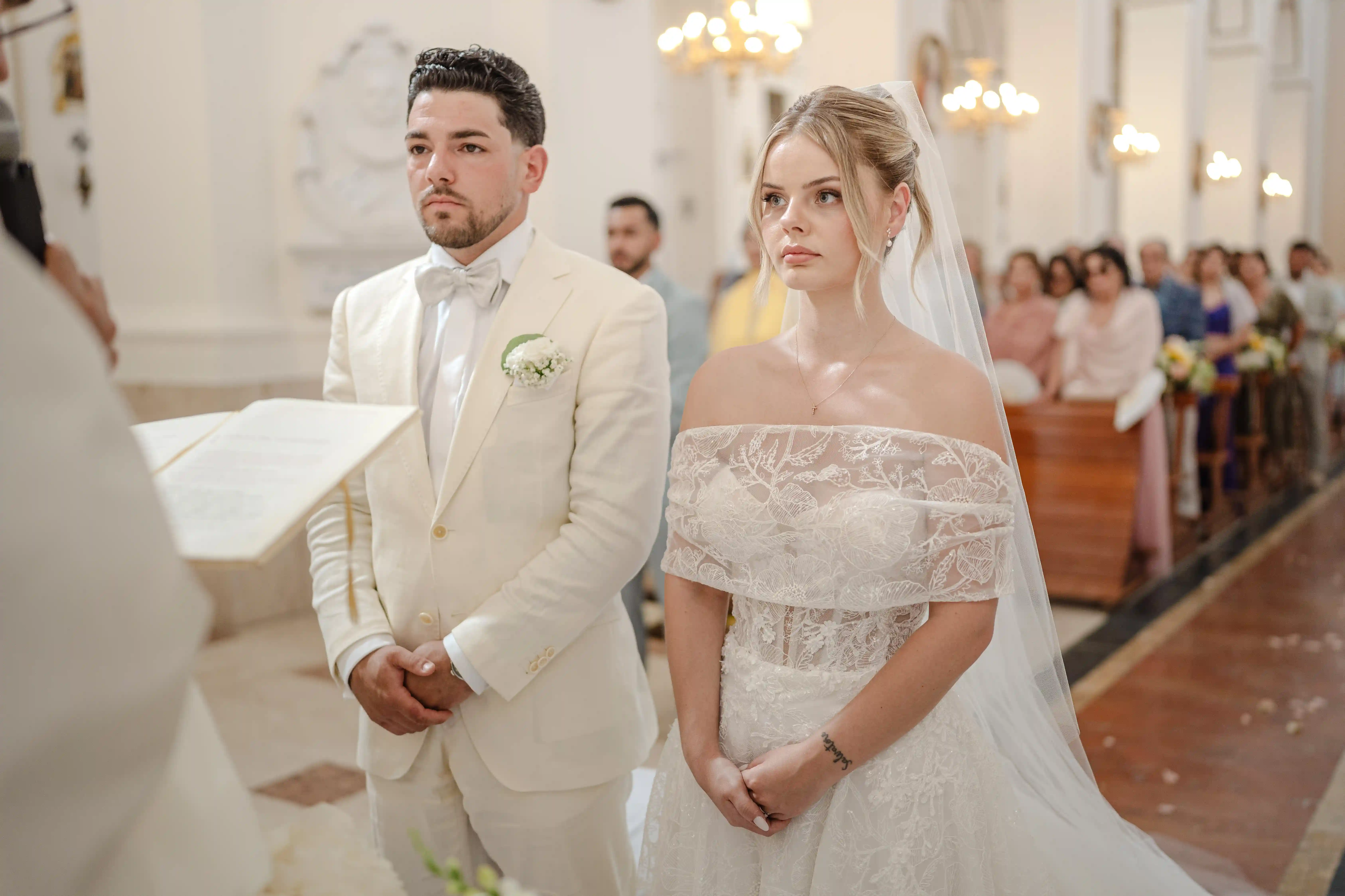 Bride and groom during ceremony Bride and groom standing together during wedding ceremony inside elegant Sicilian church