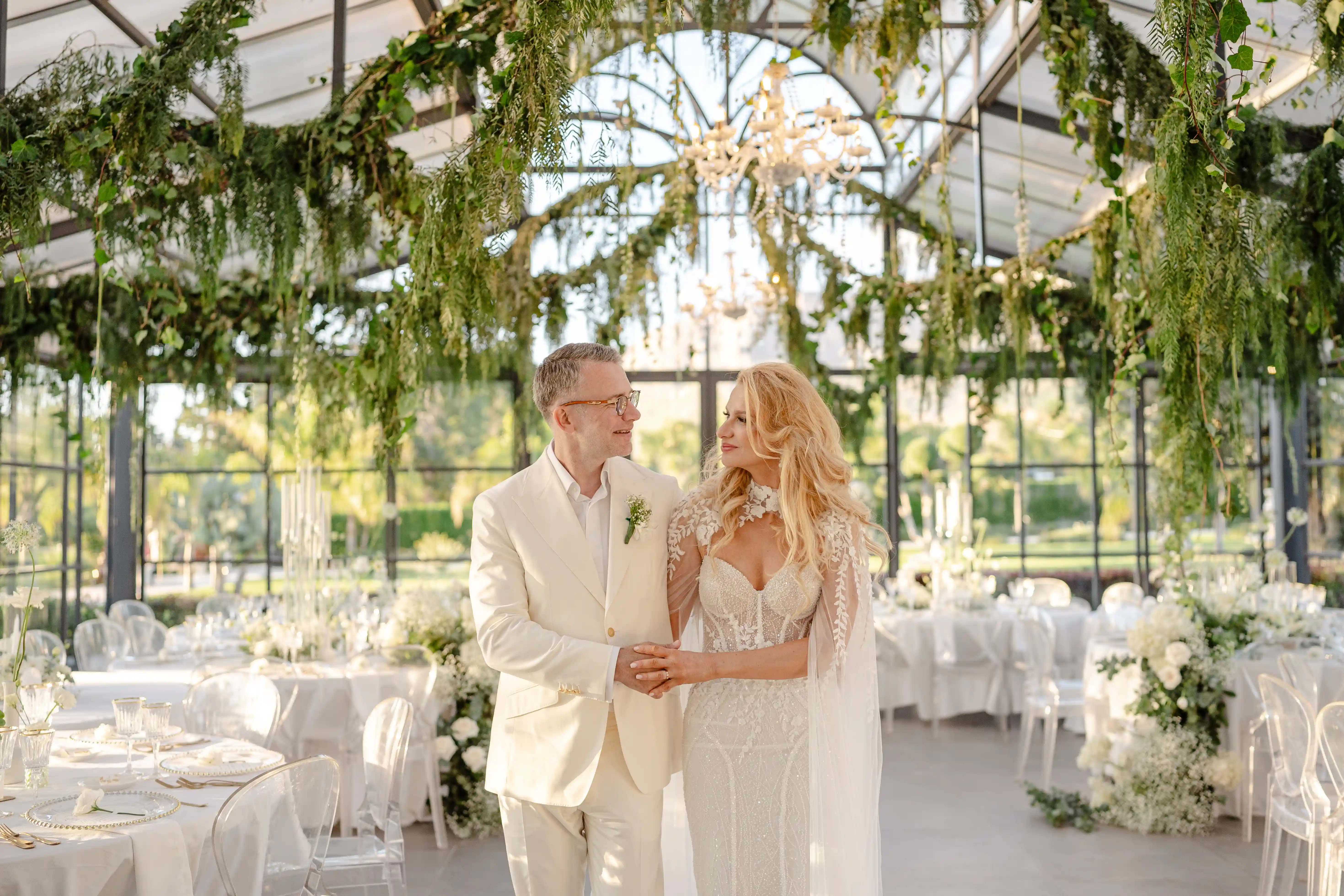 Romantic portrait of bride and groom inside a greenhouse surrounded by greenery in Sicily