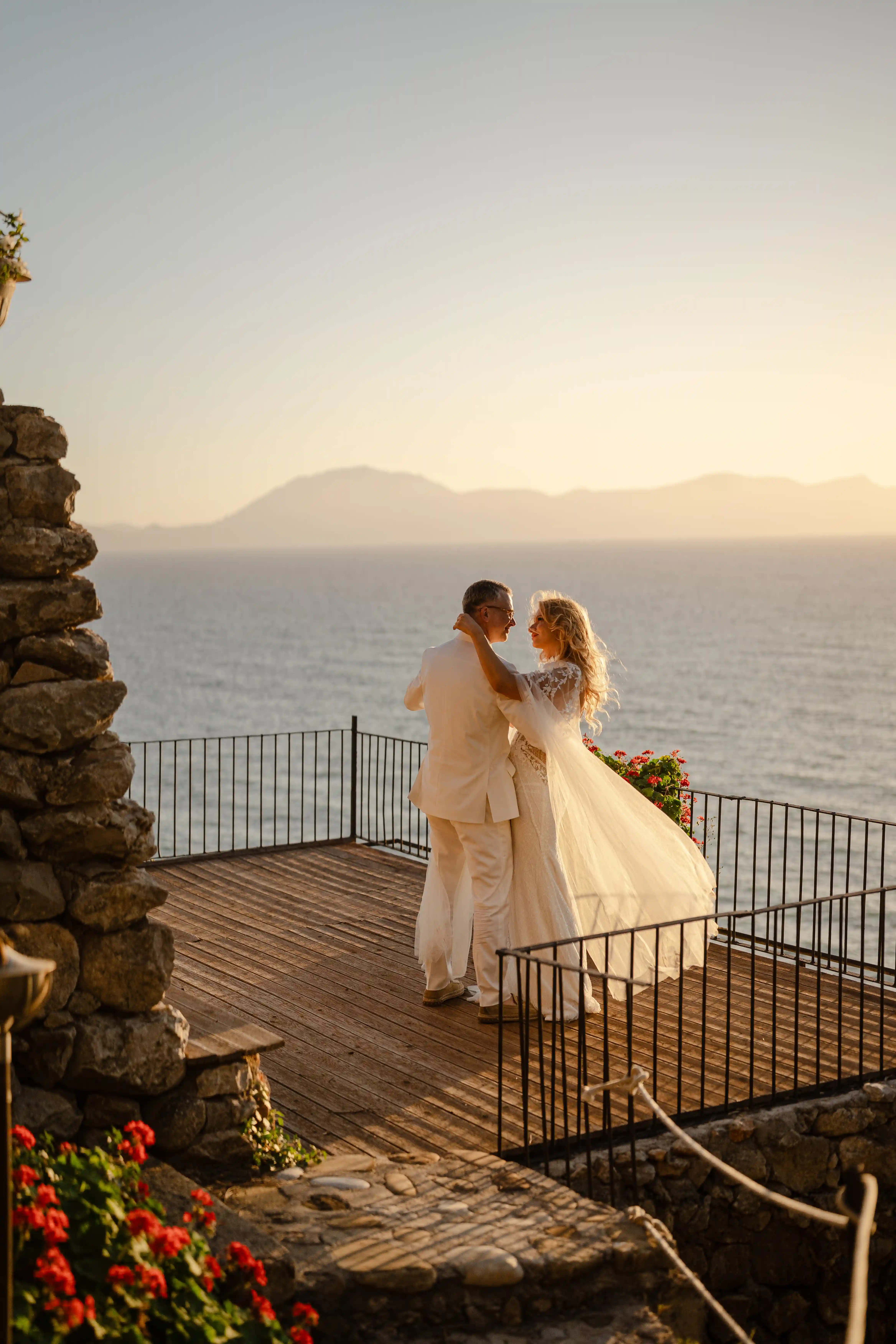 Bride and groom embracing on a sea-view terrace at sunset in Sicily elopement